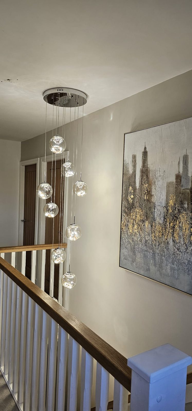 Cascading glass orb pendant light over a stairwell, installed by Z Electricals
